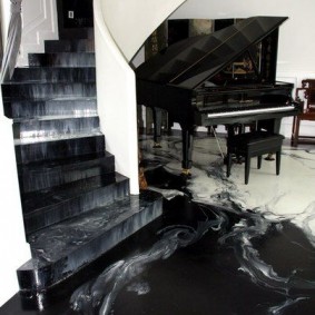 البيانو الكبير الأسود في القاعة مع الدرج