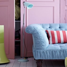 أريكة زرقاء في غرفة ذات جدران وردية