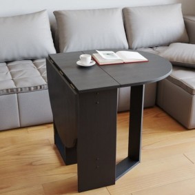 Black table in front of a gray sofa