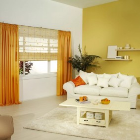 Balts dīvāns pie dzeltenās sienas
