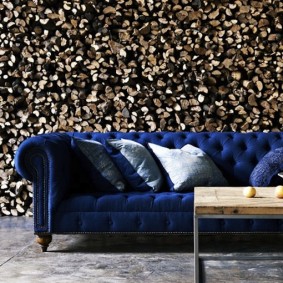 Classic sofa on the background of photo wallpaper with firewood