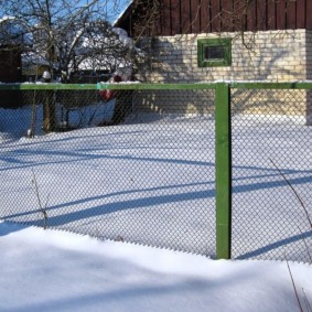 سياج شبكة خضراء في فصل الشتاء في الكوخ