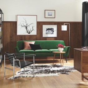 أريكة خضراء في غرفة ذات زخرفة خشبية