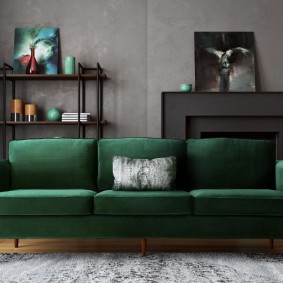 Gri duvarlı bir odada koyu yeşil kanepe