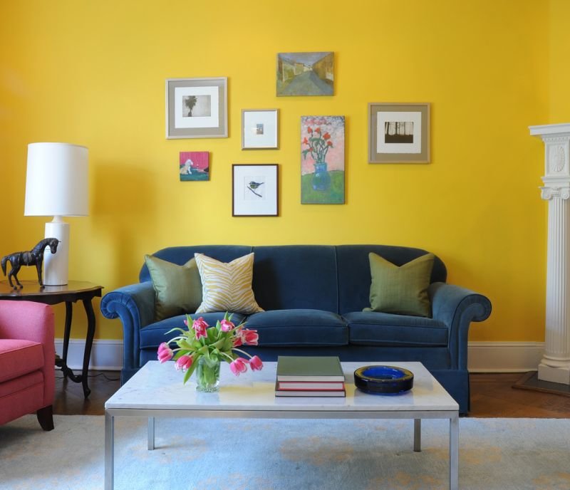 Blue sofa on a yellow wall background