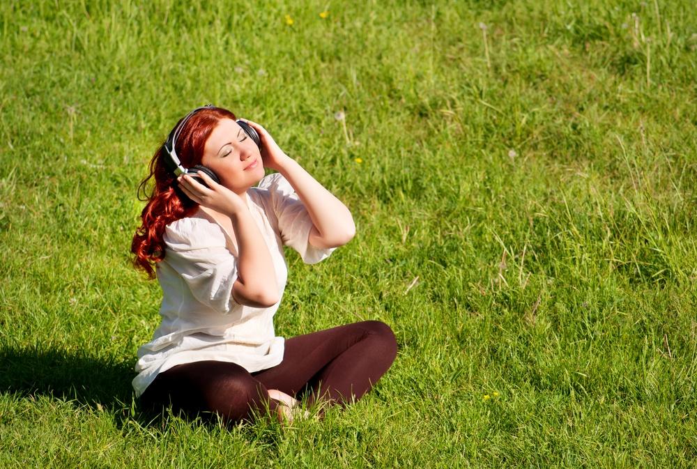 ילדה באוזניות על מדשאה של אחו