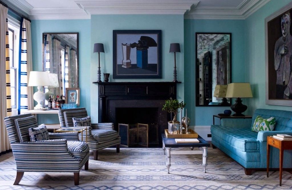 Cheminée noire dans le salon avec un canapé en bleu clair