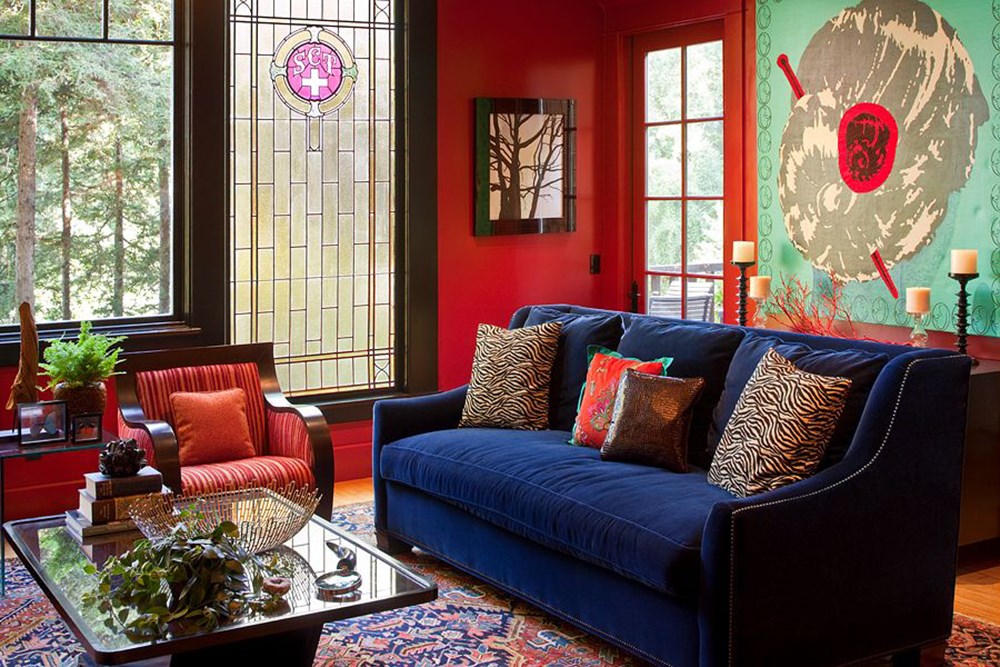 Canapea albastră în sufragerie cu pereți roșii