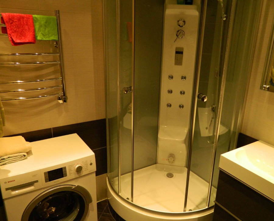 Kompakta dušas kabīne vannas istabā ar veļas mašīnu