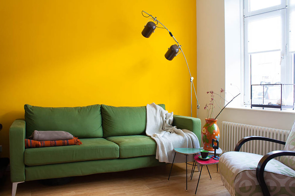 Sarı duvarın yanında yeşil kanepe