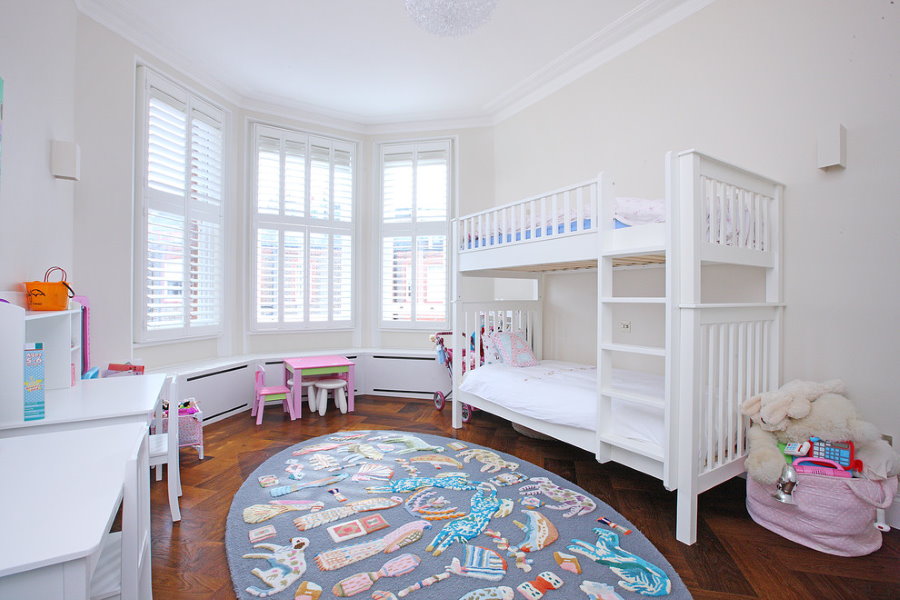 Interiorul unei camere pentru copii cu mobilier alb