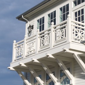 Balcon blanc sur la façade d'une maison en bois