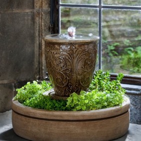 Decorative fountain with living plants on the windowsill of the apartment