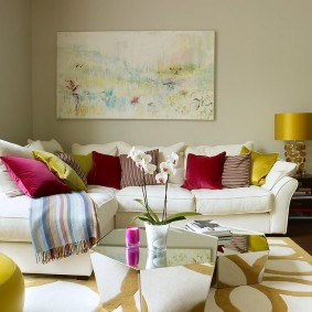 Daudzkrāsaini spilveni uz balta dīvāna