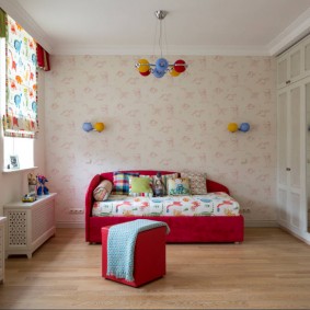 Red bed in a room with pastel wallpaper