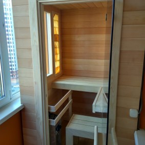 Interior de una pequeña sauna en el balcón de un edificio de cinco pisos.
