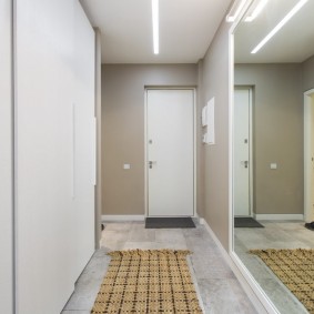 Milzīgs spogulis divu guļamistabu dzīvokļa koridorā