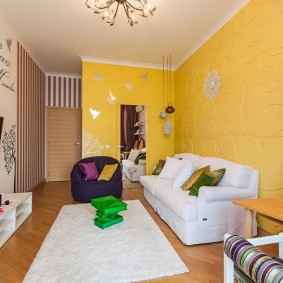 Sofa trắng gần tường màu vàng