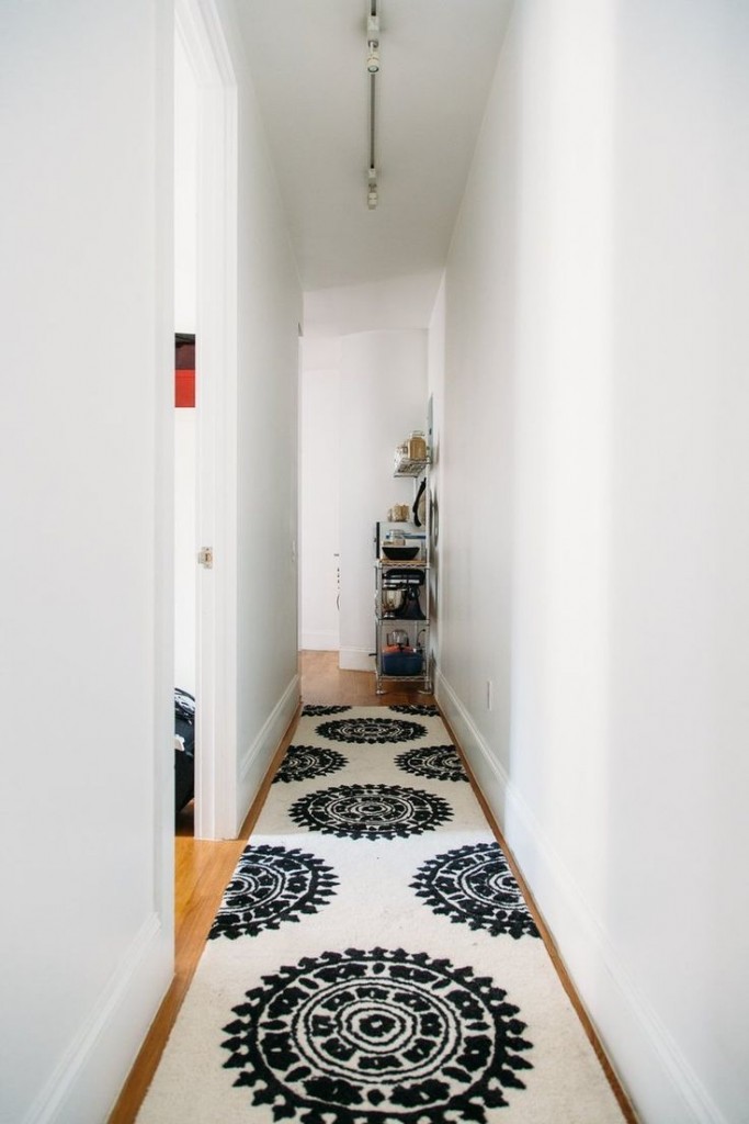 A long rug in a very narrow hallway