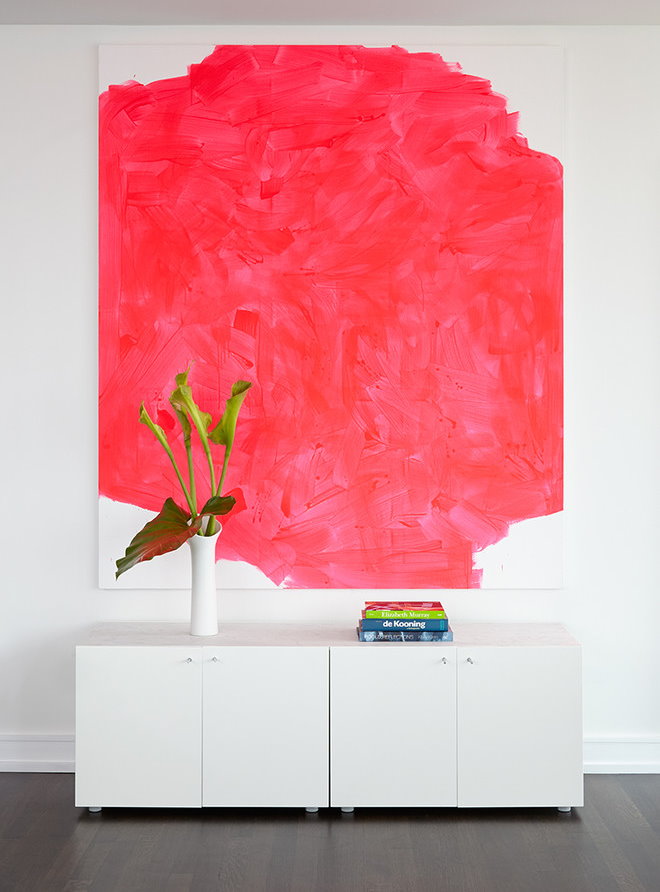 Sarkana abstrakcija uz viesistabas baltas sienas