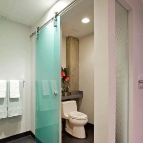Floor-mounted toilet behind a glass partition
