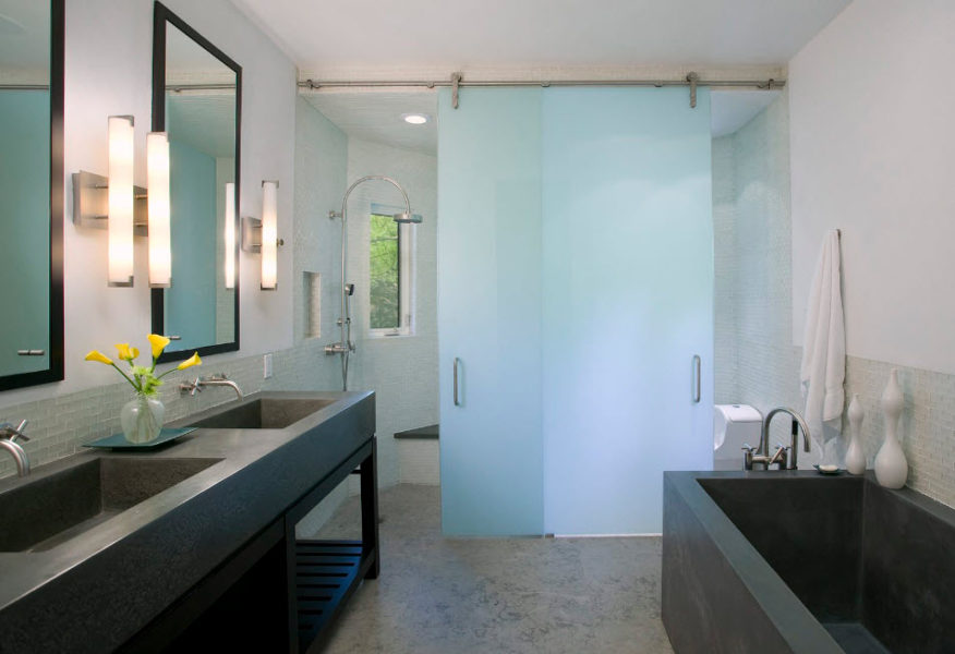 Portes coulissantes en verre dans une salle de bain spacieuse