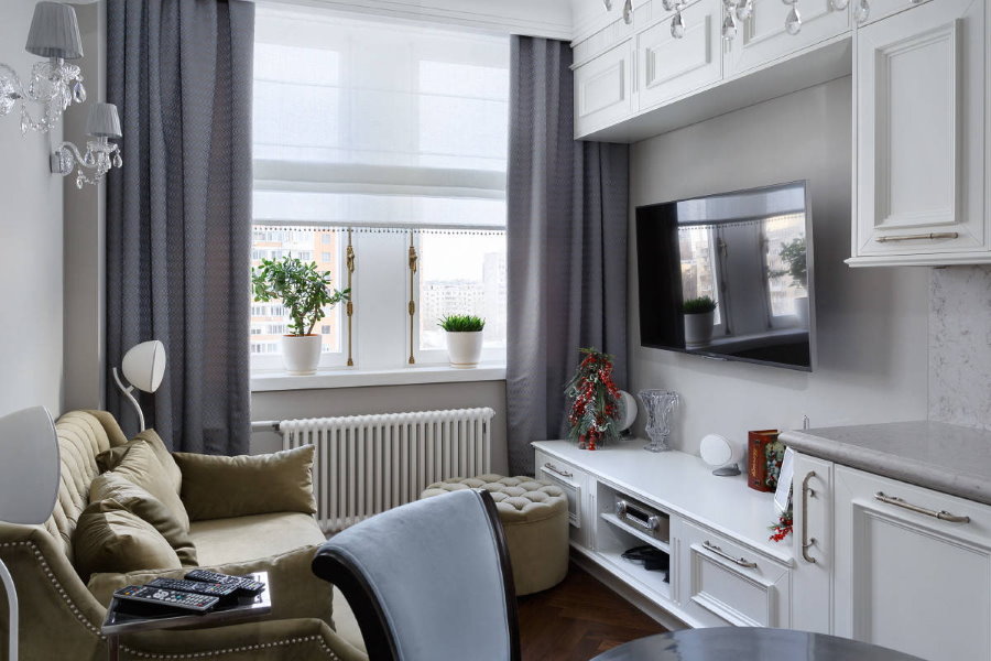 Salon confortable avec des rideaux gris sur la fenêtre.