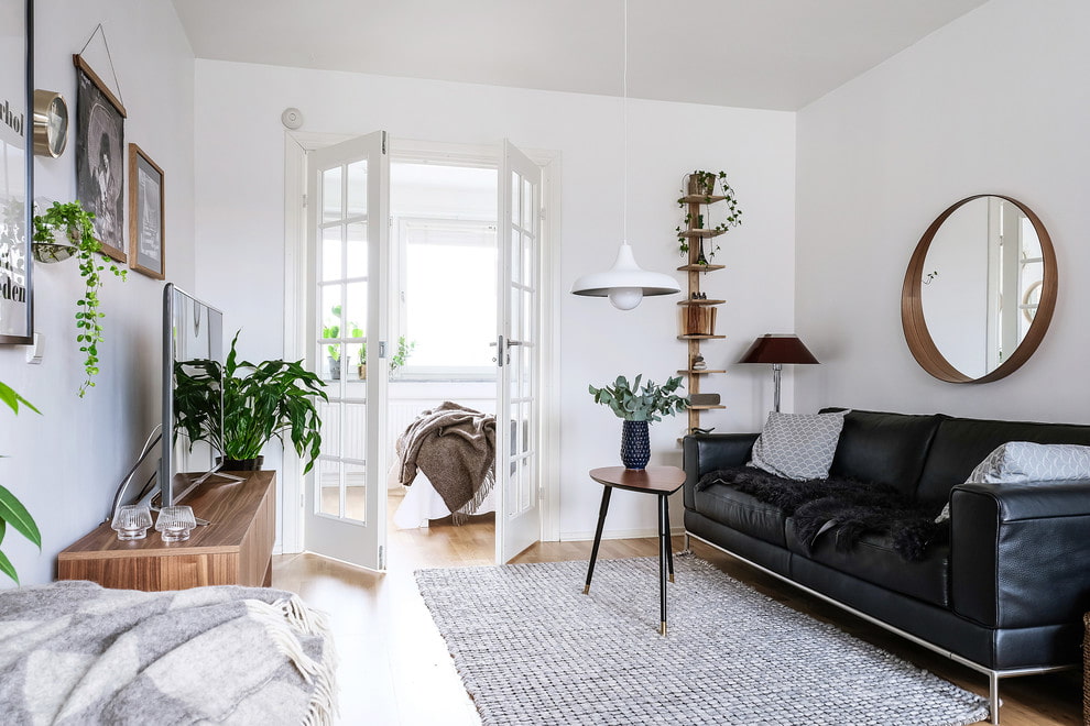 Black sofa in a white walk-through living room